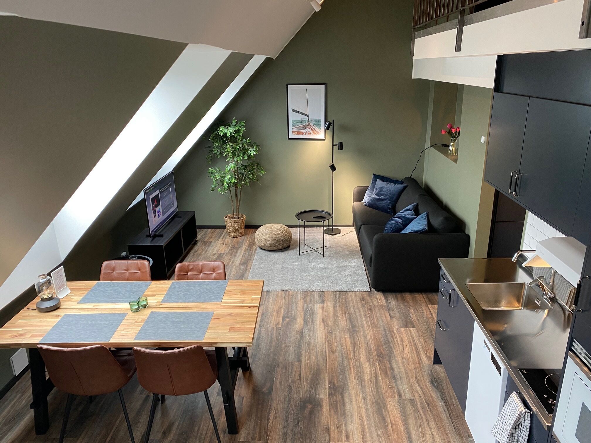 A modern loft apartment with a dining area, living space, and kitchen.