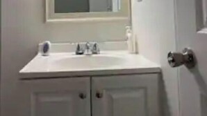 A bathroom with a white sink, mirror, and cabinets. - Emmar Blue + Fishing Lake/ Pond  (Charlotte)