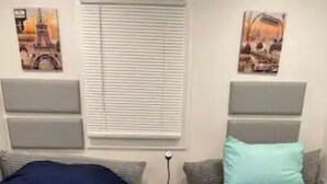 A bedroom with two beds, a nightstand, and artwork on the walls. - Emmar Blue + Fishing Lake/ Pond  (Charlotte)