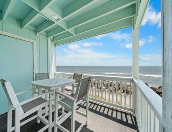 A covered outdoor seating area with a view of the ocean.