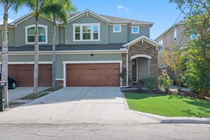 A two-story residential house with a garage, a stone accent wall, and a well-maintained lawn. - Beautiful Home Located in Best Location of Tampa (Tampa)