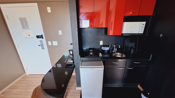 A compact kitchen with a refrigerator, stove, sink, and a small dishwasher. - Locking s Barro Preto 7 (Belo Horizonte)