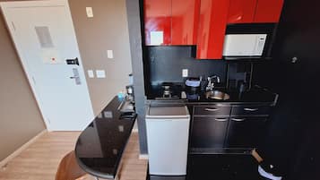 A compact kitchen with a refrigerator, stove, sink, and a small dishwasher.