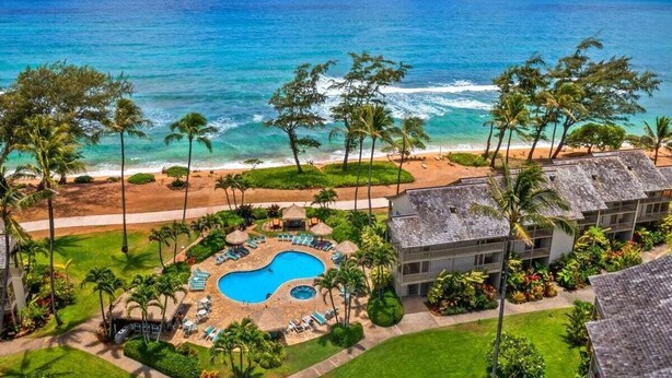 A resort with a pool, beach, and ocean view.