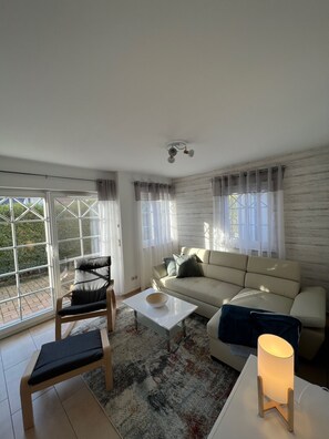 A modern living room with a sofa, a coffee table, a chair, and a lamp.