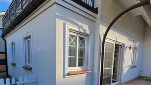 A house with a white exterior, a picket fence, and a small garden area with gravel and grass.