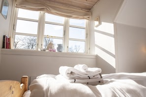 A bedroom with a bed, a window with curtains, and a view of trees outside. - Guesthouse on the Danish German border (Krusaa)