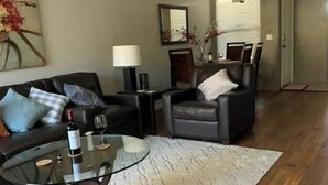 A living room with a round glass coffee table, two armchairs, a sofa, a lamp, and a painting on the wall. - Luxury 2B 2B@ Catalina Foothills Resort - Tucson (Tucson)
