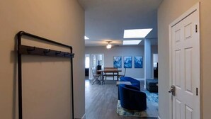 Ein Flur mit einer Bank, einem Deckenventilator und einer Tür.