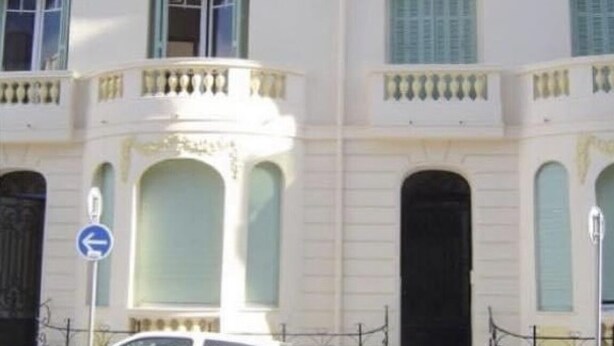 A white building with arched windows and balconies. - Charming 2-room apartment in town center, 5 minutes from the sea (Nice)