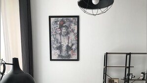 A modern living room with a grey sofa, a wooden coffee table with a tray of pastries, a black floor lamp, a framed abstract painting, and a metal shelving unit with a vintage camera. - Charming 2-room apartment in town center, 5 minutes from the sea (Nice)