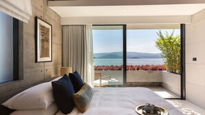 A modern bedroom with a large bed, a tray with tea and cups, and a balcony with a view of the sea and mountains. - Kerem Luxury Beachfront Villas (Koh Samui)