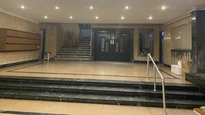 A lobby with a marble staircase, a black elevator, and a row of wooden lockers. - Nile View Apartment - Sleeps 4 & Balcony (Cairo)
