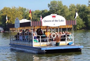 A boat with a sign reading 'Queen of the Lake' on a body of water.