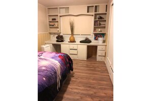 Une chambre à coucher avec un lit, un bureau et une armoire.