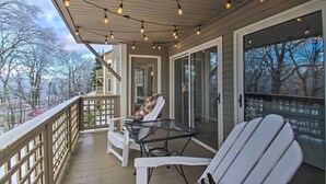A covered porch with a seating area, including a table and chairs, overlooking a snowy landscape. - Wintergreen Resort Condo: Walk to Ski Lift! (Wintergreen Resort)