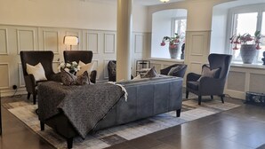 Una sala de estar elegantemente amoblada con un conjunto de sofás, sillones y una mesa de centro.