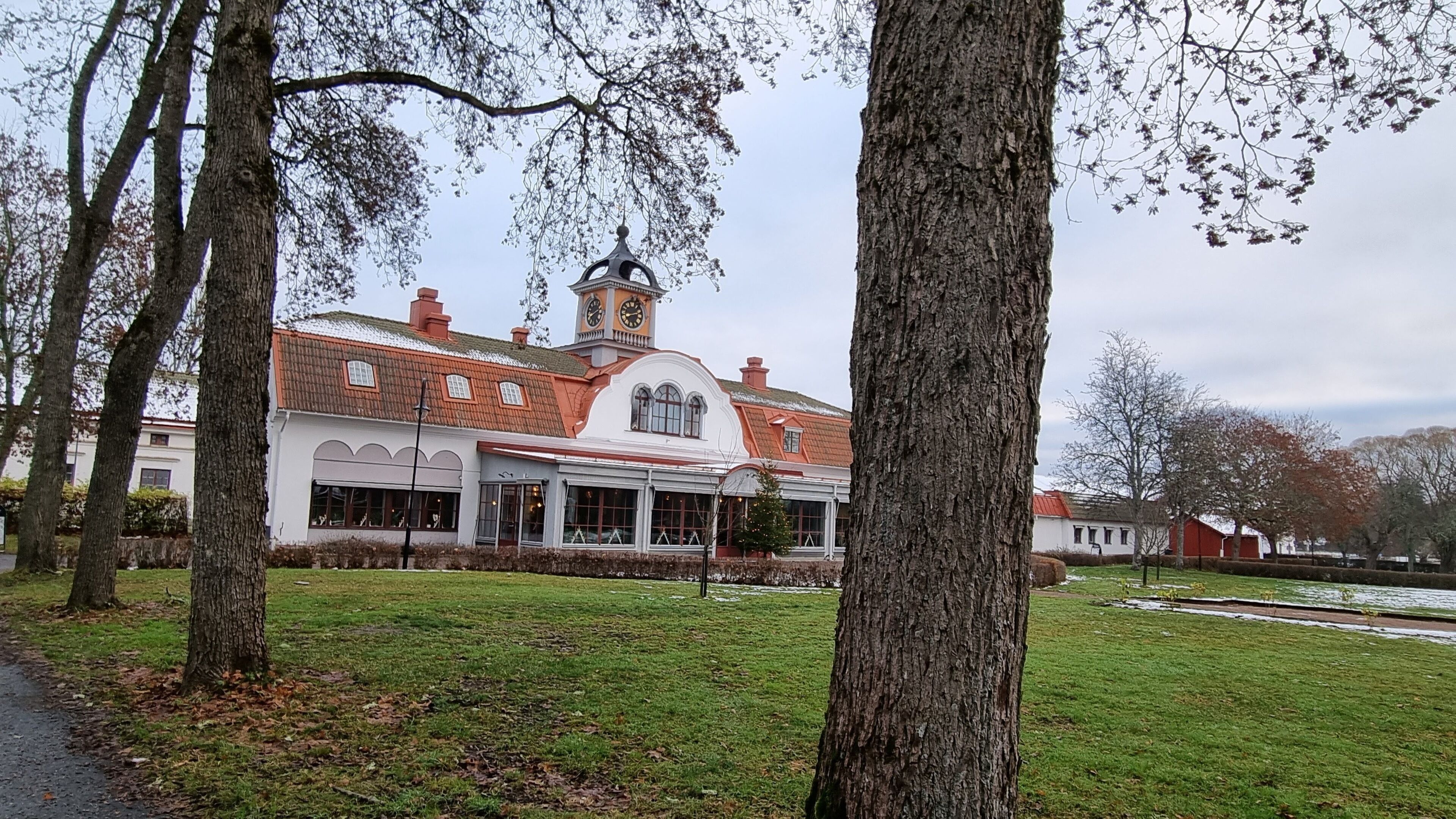 A building with a clock tower, large windows, and a red roof.