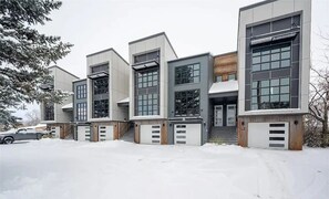 Un edificio moderno de varios pisos con amplios ventanales y entrada de garaje.