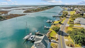 Una zona costera con un puerto deportivo, casas y una carretera.