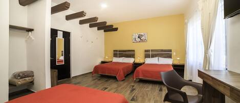 Habitación de hotel con dos camas, un escritorio, una silla, un espejo y un cuadro en la pared.