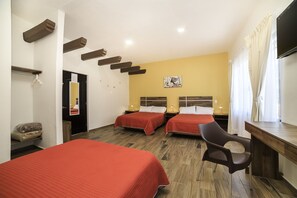 Habitación de hotel con dos camas, un escritorio, una silla, un espejo y un cuadro en la pared.
