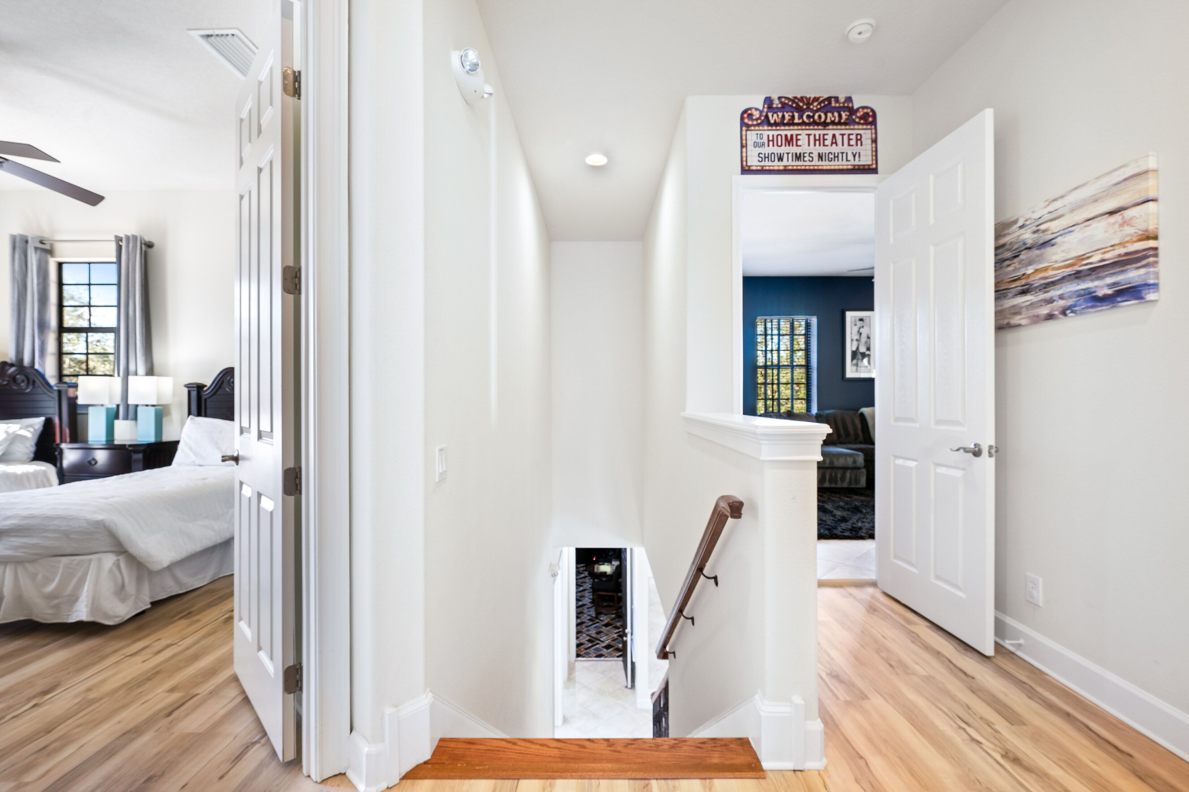A hallway with a staircase leading to a home theater.