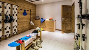 A ski room with a bench, skis, and a snowboard. - Chalet Snow Dream in le Bettaix (Les Belleville)