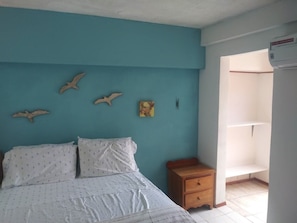 A bedroom with a bed, a nightstand, and a wall with bird decorations.