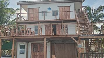 A two-story building with a wooden facade, multiple balconies, and a sign indicating Belize.