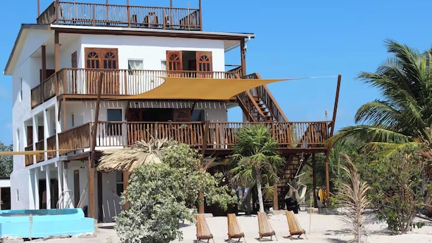 Un immeuble à plusieurs étages doté de balcons, d’une piscine et d’un espace extérieur aménagé pour s’asseoir.