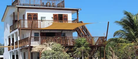 Un immeuble à plusieurs étages doté de balcons, d’une piscine et d’un espace extérieur aménagé pour s’asseoir.
