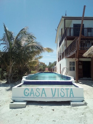 A swimming pool labeled 'GASA VISTA' on a sandy beach with a building in the background.