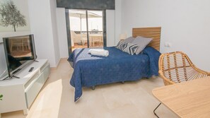 Una camera da letto con un letto, una televisione, una sedia e una finestra.