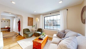 A modern living room with a sofa, armchair, and a wooden coffee table.