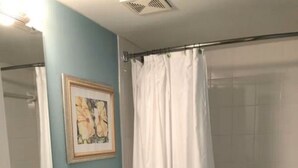 Un baño con lavamanos, inodoro y cortina de ducha.