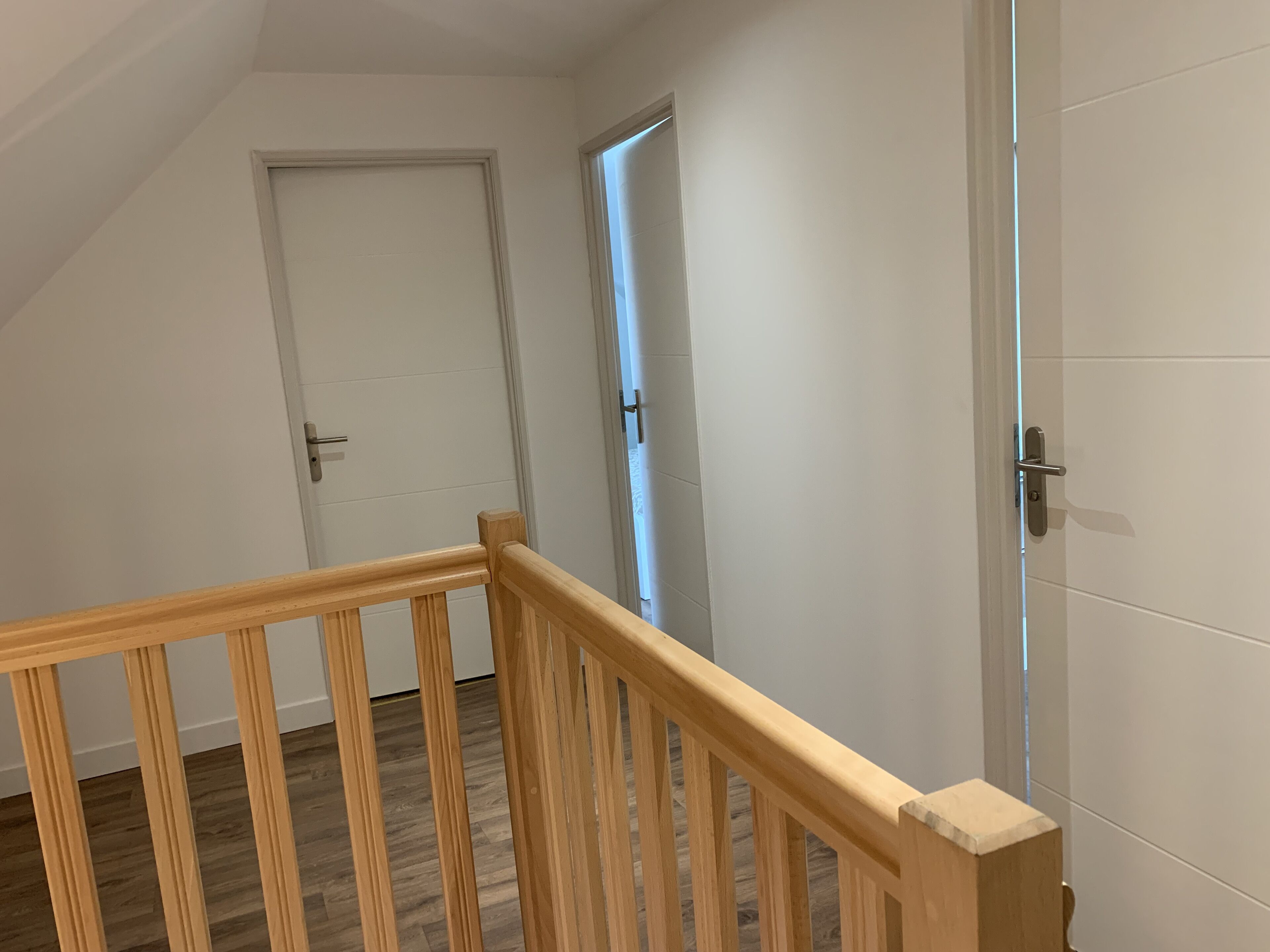 Una escalera con barandillas de madera que lleva a una puerta.