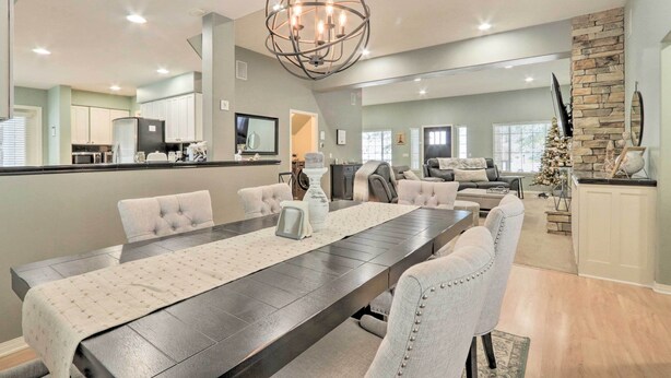 A spacious dining area with a long table, comfortable seating, and a modern chandelier. - Crystal Bay Home w/ Fireplace Near Ski Resorts (Post Falls)