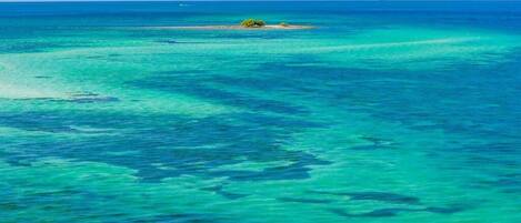 A clear view of turquoise ocean waters with a small island in the distance.