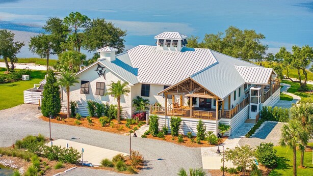 A coastal house with a large deck, a covered porch, and a view of the ocean. - Luxe Coastal Dream w/Ocean Views + Private Pool (Port St. Joe)