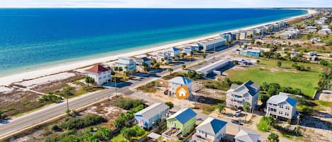 Zona residencial costera con casas, una playa y cielo despejado.
