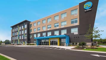 Welcome to a stylish hotel with a flat roof and a symmetrical design, featuring a blue canopy and double doors at the entrance.