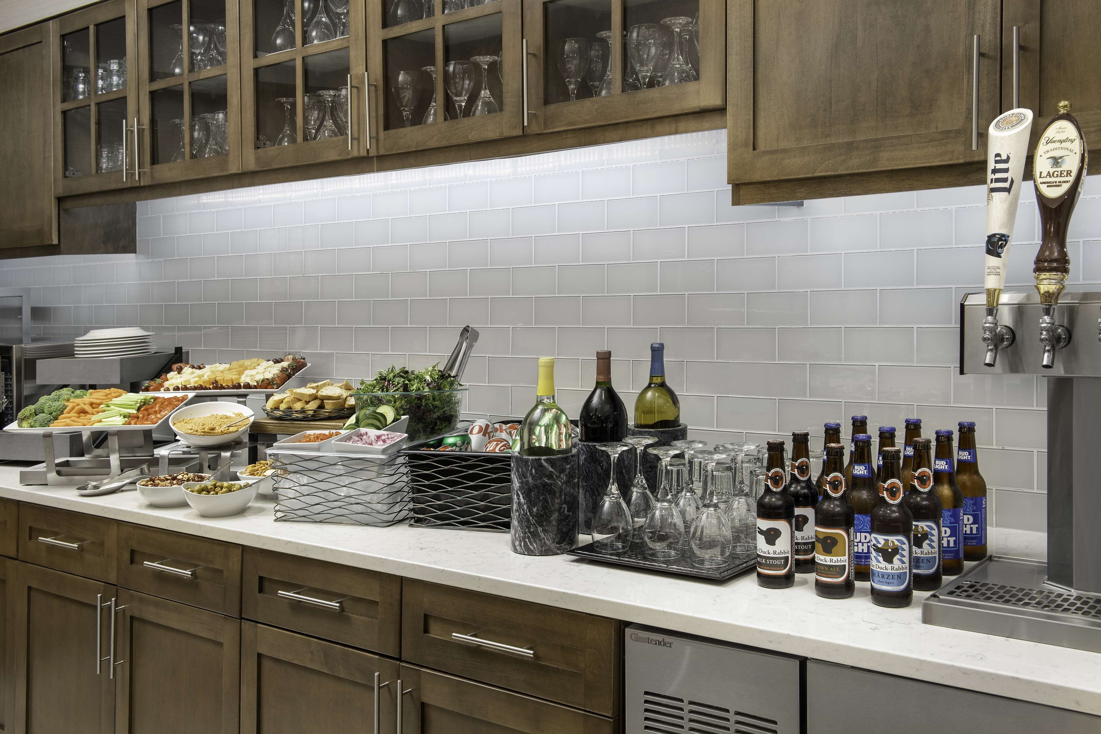 Una cocina con barra libre, botellas de vino y grifos de cerveza.
