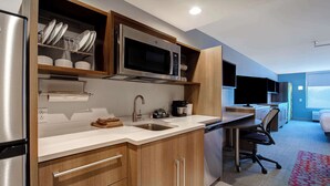 A modern kitchen with stainless steel appliances, wooden cabinets, and a built-in microwave. - Home2 Suites By Hilton Shepherdsville Louisville South (Louisville)