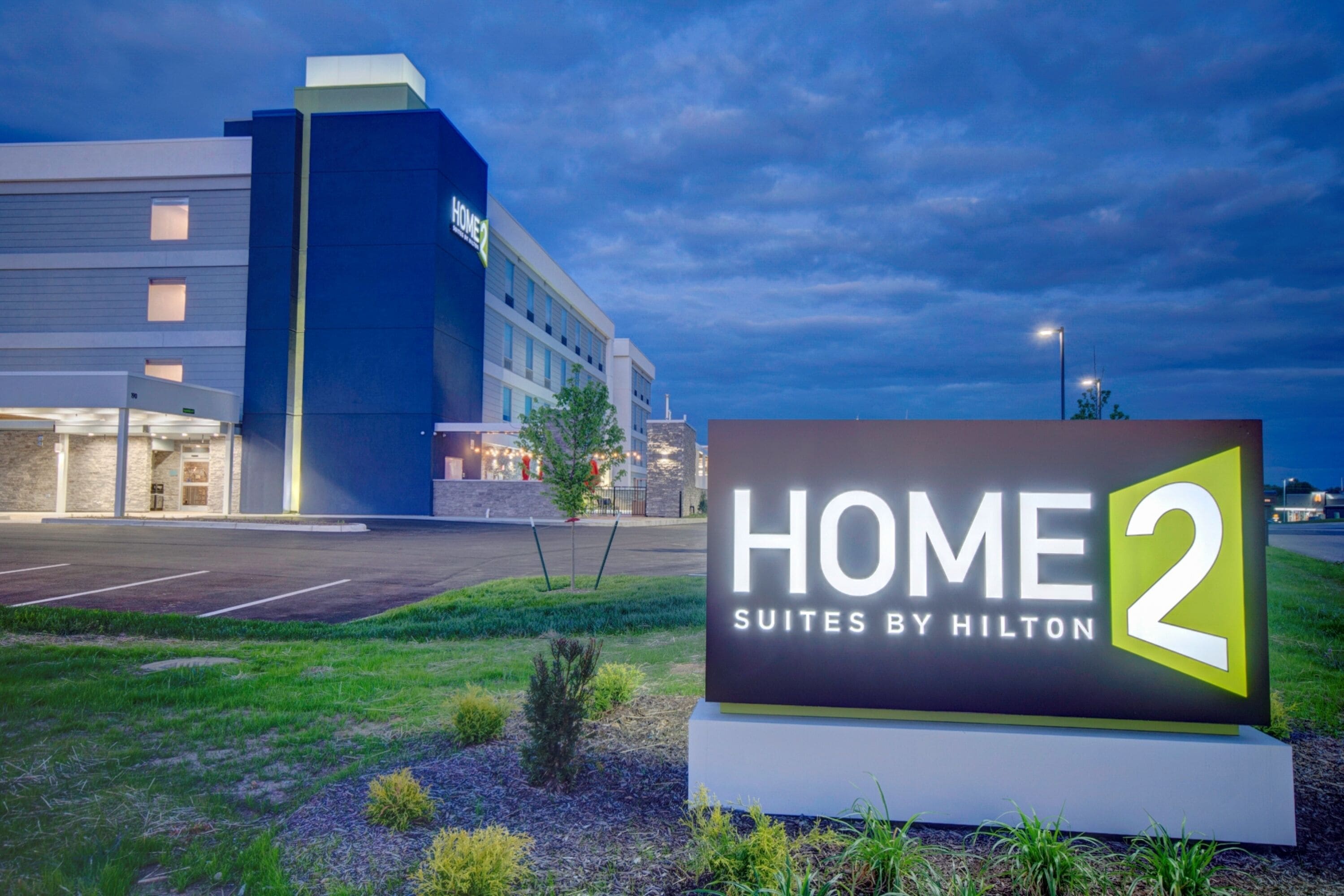 Une enseigne d’hôtel indiquant « HOME 2 Suites by Hilton », ce qui signifie qu’il s’agit d’un hôtel proposant des suites.