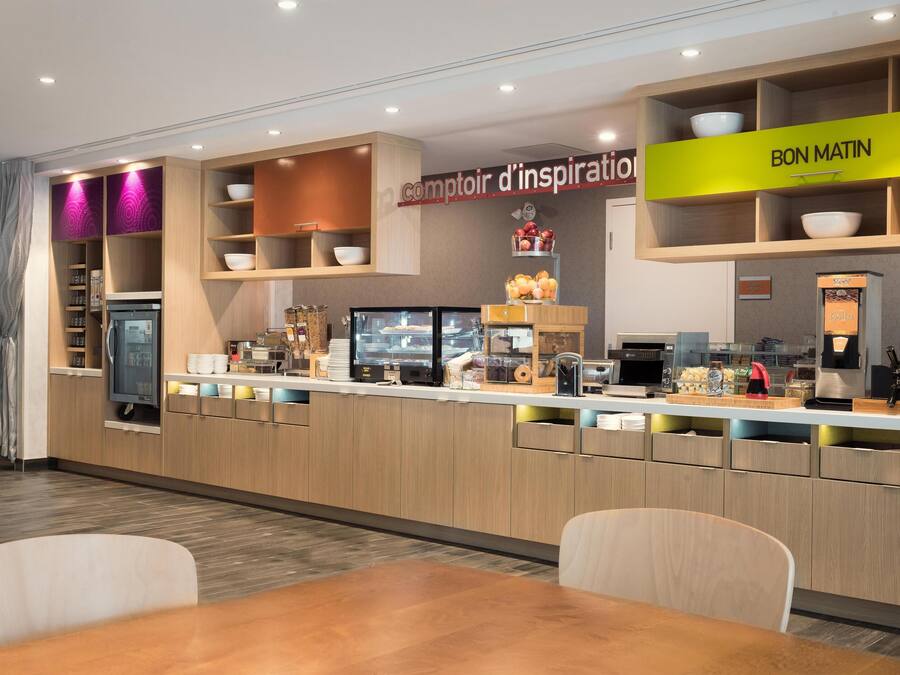 A modern breakfast bar with a 'Bon Matin' sign, a refrigerated display case, and a coffee machine.
