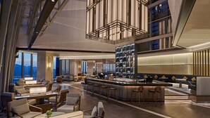 A modern hotel lobby with a bar area, seating arrangements, and a view of the cityscape. - Doubletree By Hilton Zhuhai Hengqin (Zhuhai)