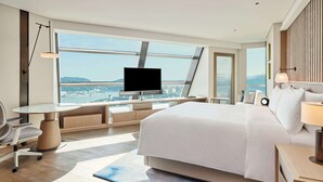 A modern hotel room with a large bed, a desk, a television, and a view of the city. - Doubletree By Hilton Zhuhai Hengqin (Zhuhai)