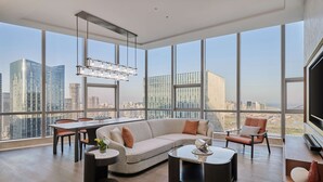A modern living room with a large window, a sofa, a dining table, and a TV. - Doubletree By Hilton Zhuhai Hengqin (Zhuhai)