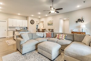 A modern living room with a sectional sofa, a dining area, and a kitchen. - Family-Friendly Ozark Villa - Centrally Located (Ozark)